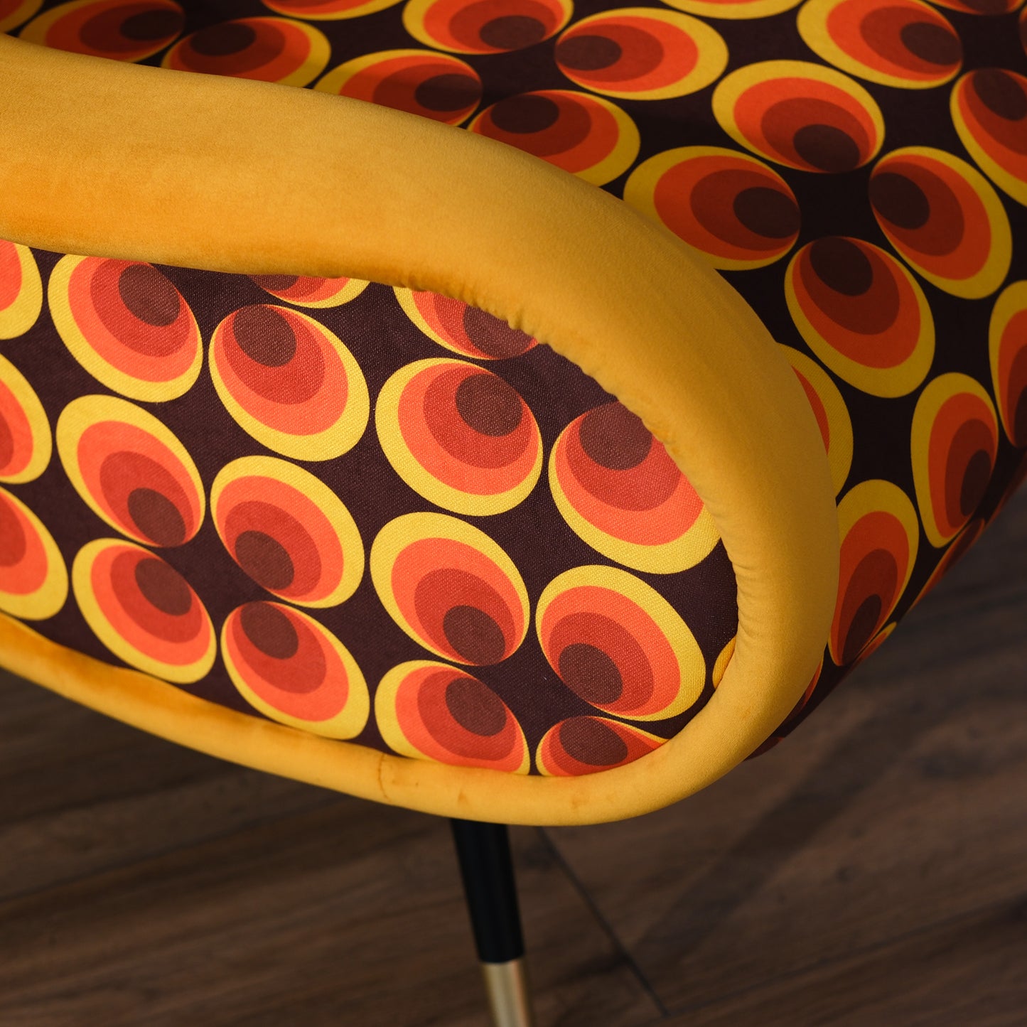 Poltrona Miss motivo vintage arancio, senape e marrone, gambe nere dettaglio ottone