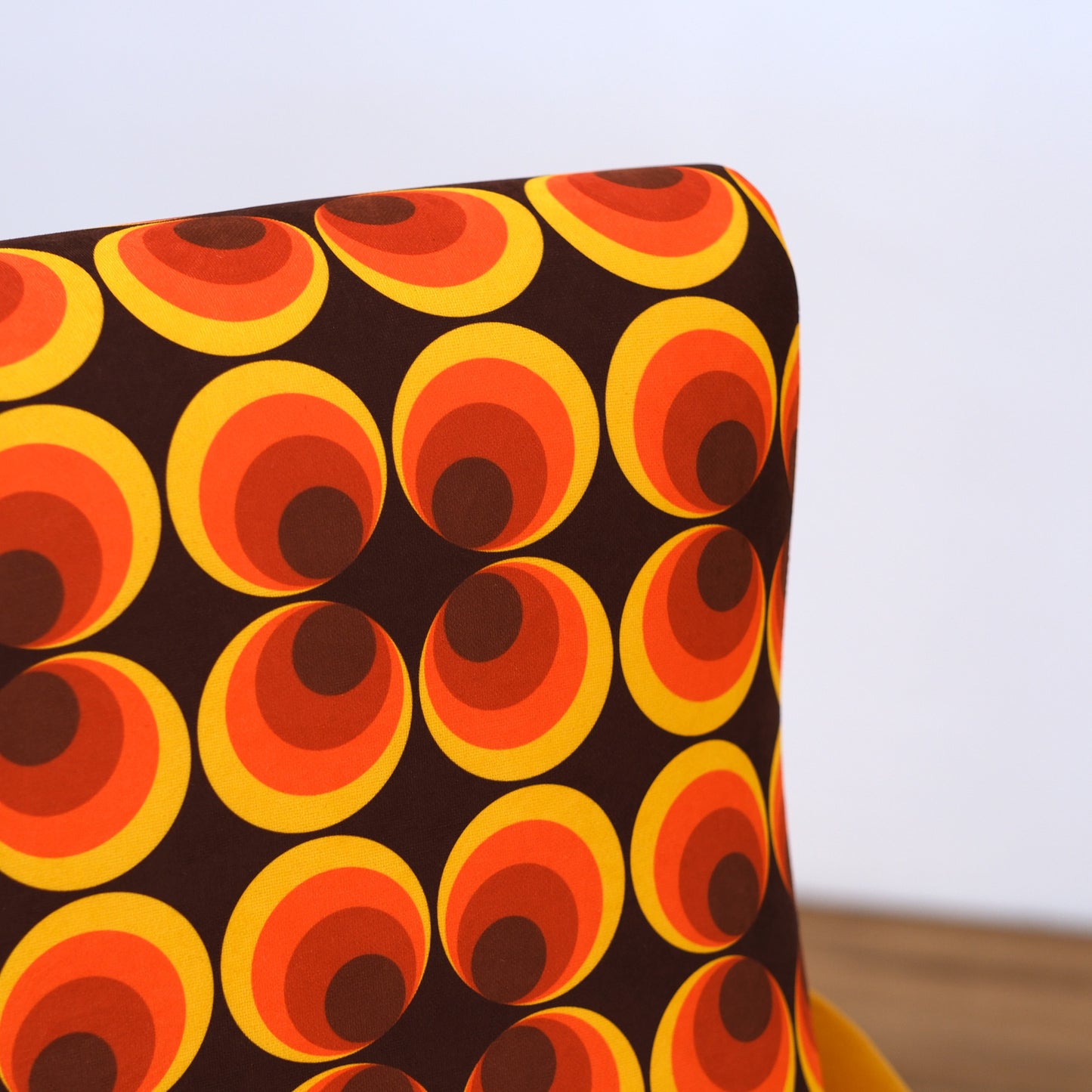 Poltrona Miss motivo vintage arancio, senape e marrone, gambe nere dettaglio ottone