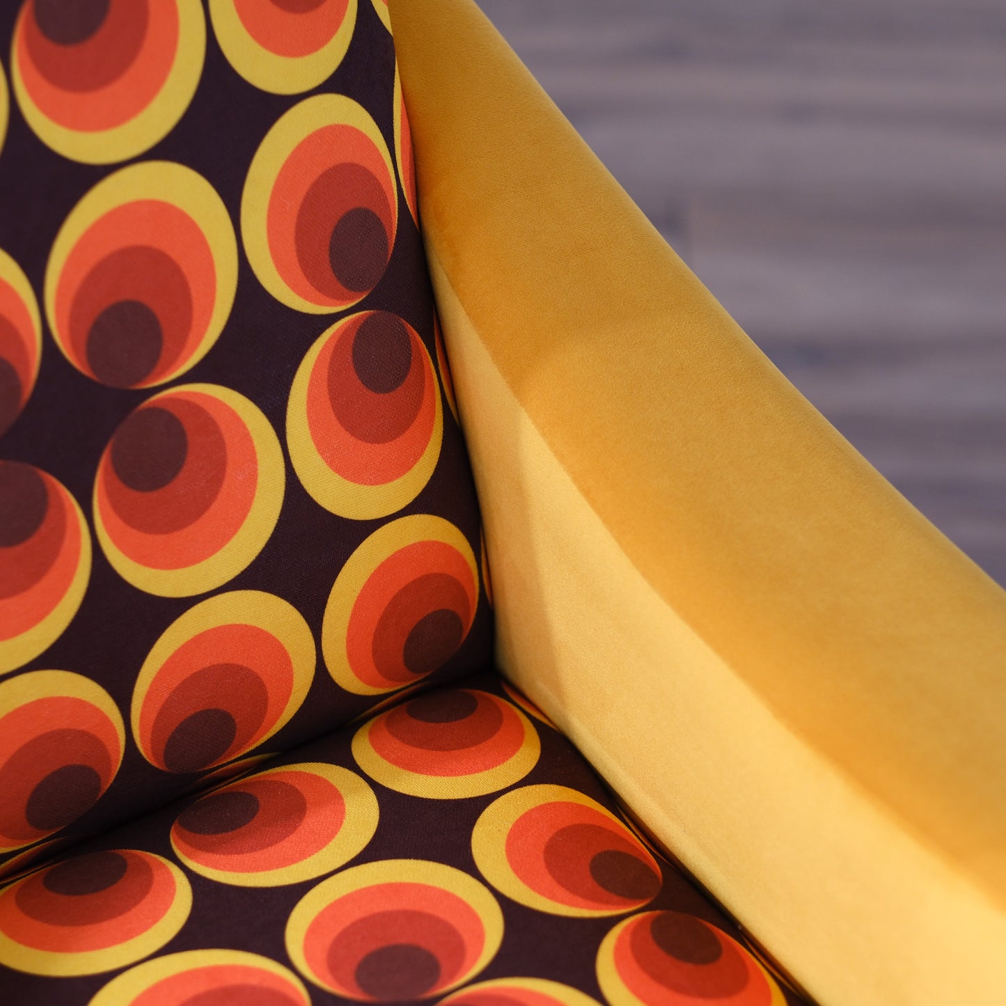 Poltrona Miss motivo vintage arancio, senape e marrone, gambe nere dettaglio ottone